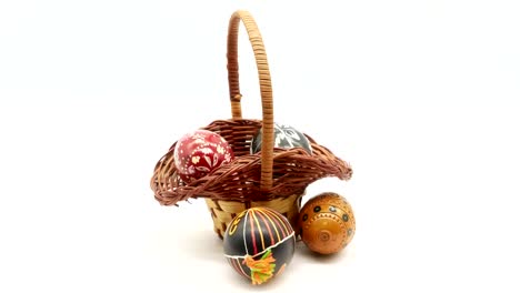 decorative-basket-with-painted-Easter-eggs-on-white-background