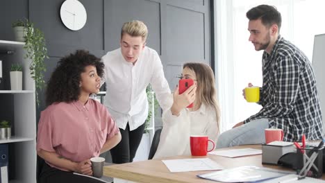 Business-team-watching-social-media-content-on-phone