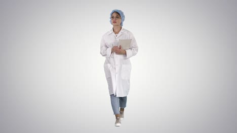 Mujer-doctor-caminando-sosteniendo-tableta-sobre-fondo-degradado