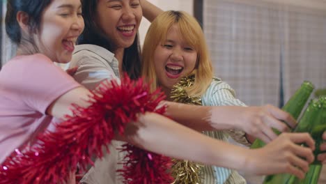 Group-of-Asian-women-party-at-home,-female-drinking-beer-dancing-and-singing-having-funny-together-in-living-room-in-night.-Teenager-young-friends-play-game,-celebrate-holiday-concept.-Slow-motion.