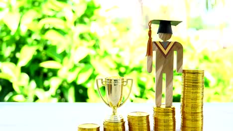 Sparen-Sie-Geld-für-die-Ausbildung-Absolvent-in-Erfolg-Konzept:-Steigende-Münzen-mit-Studenten-Universitätsmodelle,-goldene-Trophäe-Gewinner,-Management-Studie-Wettbewerb-Führung-und-Inspiration-im-Leben