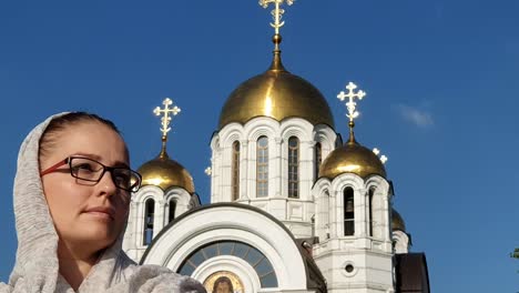 Orthodoxe-Lifestyle-Frau-im-Schal-steht-auf-dem-Hintergrund-der-orthodoxen-Kirche