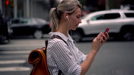 Chica-hipster-cáucaso-positiva-vestida-con-ropa-casual-caminando-por-la-ciudad-en-tiempo-de-vacaciones