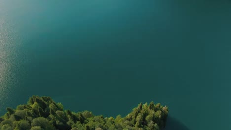 Bergsee-mit-türkisfarbenem-Wasser-und-grünem-Baum