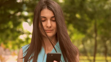 close-up-student-using-smartphone-typing-message-walks-on-pedestrian-zone