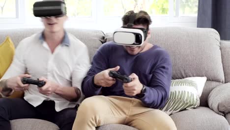 Gay-couple-relaxing-on-couch-playing-virtual-reality-games.-Exciting-mood.-Try-to-compete-together.