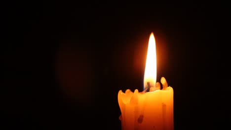 Closeup-of-candle-flame-on-black.-Old-white-candle