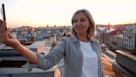 Mujer-de-mediana-edad-de-pelo-gris-haciendo-selfie-en-el-techo