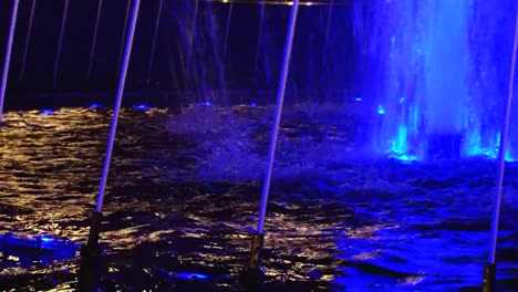 Blue-colored-fountain-jets,-spray-and-blue-lights