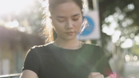 Junge-asiatische-Sportlerin,-die-mit-Herzfrequenz-auf-einer-Smartwatch-überprüft.