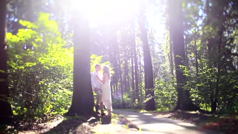 Mann-und-Frau-im-Park-oder-im-Wald-unter-Bäumen.-Haben-Sie-ein-Datum-in-Natur-Tilt-Shift.-Junges-Paar-Umarmung-an-einen-Baum-gelehnt.-Romantische-Erinnerungen-Zärtlichkeit-Beziehung-Liebesgeschichte