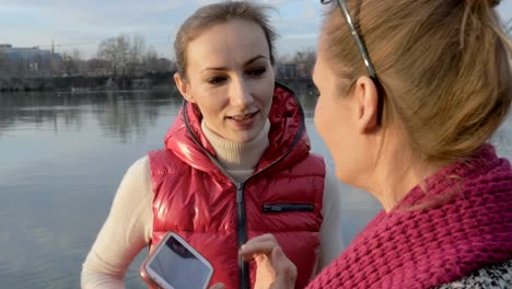 Zwei-Mädchen-Frau-Freunde-sprechen-und-Surfen-auf-Handy