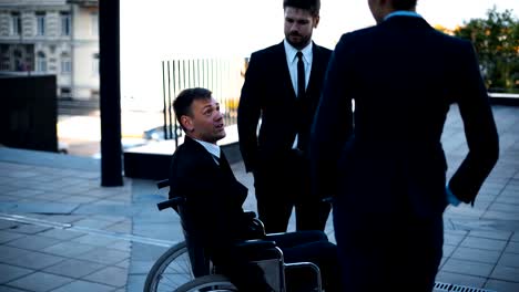 Businesspeople-and-disable-invalid-in-wheelchair-have-conversation