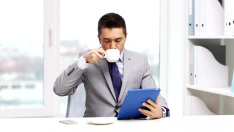 hombre-de-negocios-con-equipo-tablet-pc-PC-tomando-café-en-la-oficina