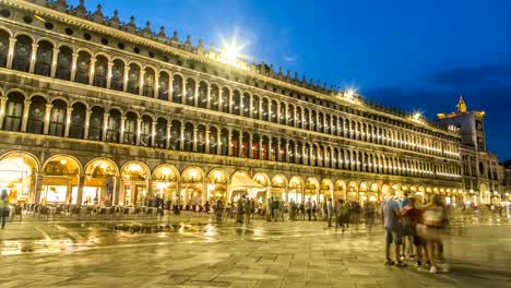 Edificio-iluminado-de-Procuratie-y-muchas-personas-en-la-Plaza-de-San-Marcos-en-la-noche