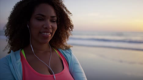 Ethnic-female-dancing-to-music-on-smart-phone