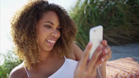 Ethnic-female-using-smart-phone-with-ear-buds