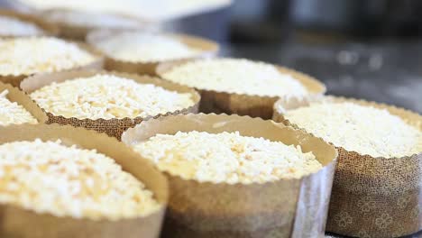 manos-de-chef-de-repostería-azúcar-en-polvo-por-aspersión-en-masa-para-dulce-de-Pascua-pan-pasteles