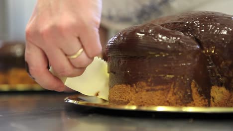 Pastry-Chef-Hände-garnieren-Ostern-süßes-Brot-Kuchen-mit-Fondants-Zucker-paste,-Nahaufnahme-auf-der-Arbeitsplatte-in-der-Konditorei