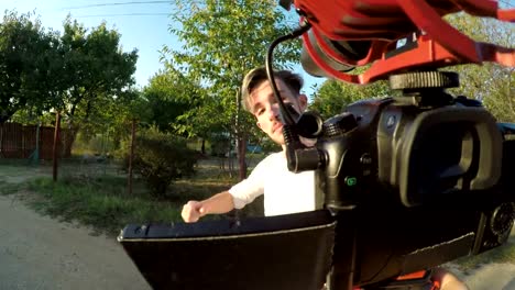 Excited-young-man-spinning-and-recording-a-video-outside-his-house-with-a-mobile-professional-camera-about-his-village-in-nature