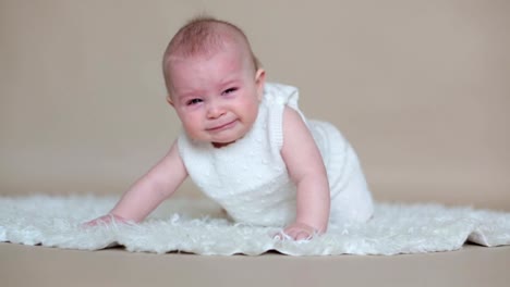 Cute-little-toddler-baby-boy,-playing-with-colorful-easter-eggs-and-little-decorative-ducks,-isolated-shot,-beige-background