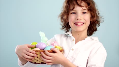 Curly-boy-with-an-Easter-basket.-First-a-serious-look-on-his-face,-then-he-laughs.-Waiting-for-a-holiday