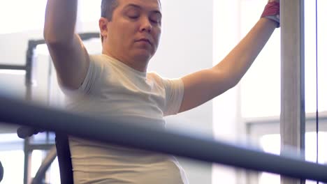 Disabled-athlete-in-a-wheelchair-getting-ready-for-training-in-gym.