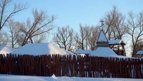 snow-covered-ancient-city-behind-wooden-palisade,-church-in-an-ancient-city