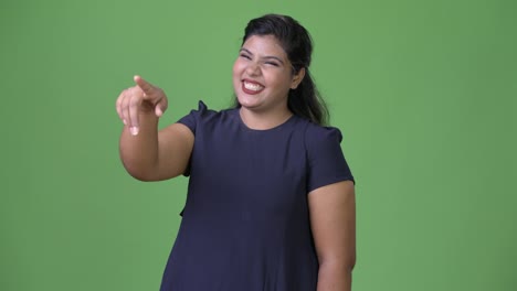 Young-overweight-beautiful-Indian-businesswoman-against-green-background