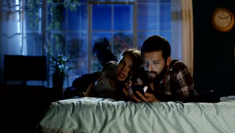 Young-couple-surfing-smartphone-on-bed