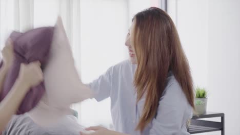 Asian-young-lesbian-couple-playing-to-each-other-with-love-moment-on-the-sofa-in-bedroom-surrounded-with-warm-sunlight.-LGBT-couple-have-a-love-moment-together-on-the-sofa-at-home.