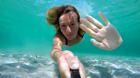 Selfie-retratos-de-nadar-bajo-el-agua-joven-en-aguas-cristalinas,-disfrutando-de-unas-vacaciones-en-Cerdeña-Italia