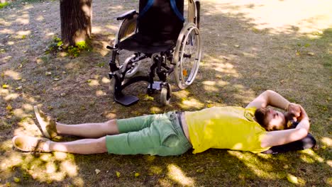 Young-disable-man-is-relaxing-on-the-ground-in-the-park