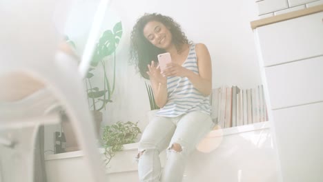 Young-woman-typing-on-mobile-phone-at-home.