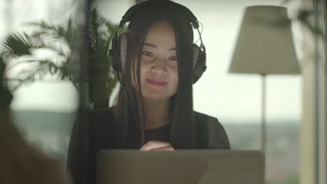 Young-woman-sitting-at-home-working-with-computer-and-chair-dancing