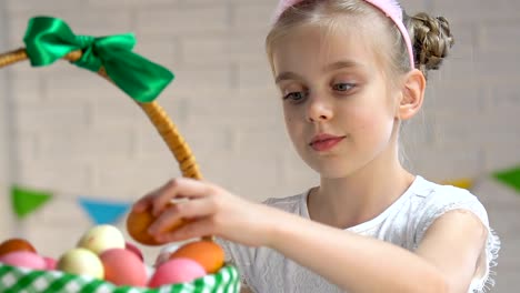 Adorable-pequeña-anfitriona-embalaje-canasta-de-Pascua-con-los-huevos-teñidos-coloridos,-tradición