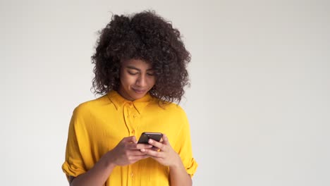 Mujer-afroamericana-de-mensajería-en-el-teléfono-móvil