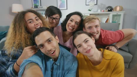 Zu-Hause-vielfältige-Gruppe-von-Freunden-tun-kollektive-Selfie,-Guy-Smartphone-hebt-Menschen-Lächeln,-lachen,-und-Ente-Lips.Young-Menschen-tun-Live-Stream-von-der-Party-nach-Hause.