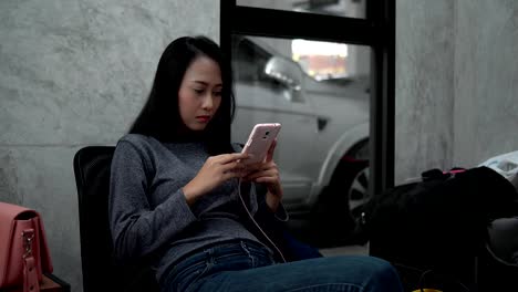 Linda-mujer-chateando-en-smartphone-en-sala-de-espera