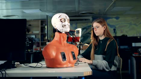 Girl-is-manipulating-robot's-face-by-means-of-a-computer