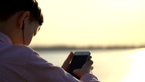 Junge-Kerl-nutzt-eine-Anwendung-auf-Ihrem-Smartphone-oder-klettert-in-sozialen-Netzwerken