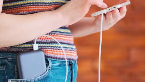 Frau-mit-Smartphone-beim-Laden-auf-der-Powerbank.