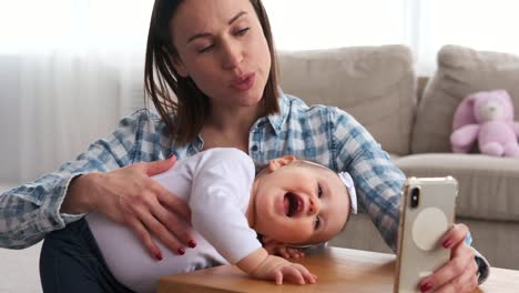 Mutter-mit-Baby-Tochter-nimmt-Selfie-zu-Hause