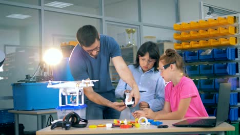 School-children-explore-drone,-copter,-aircraft-with-a-teacher-in-a-technology-class.