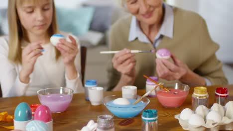 Grandmother-Teaching-Granddaughters-to-Paint-Eggs