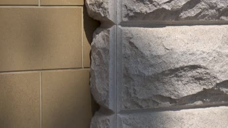 The-facade-of-the-building-is-trimmed-with-brown-tiles-and-decorative-stone-on-a-sunny-day.-Design-and-architecture.-Close-up