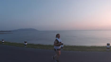 Asiatische-Frauen-joggen-in-der-Straße-am-frühen-Morgen-Sonnenlicht-am-Wasserspeicher-Pa-Sak-Jolasid-Dam.-Konzept-des-Gewichtsverlustes-mit-Bewegung-für-die-Gesundheit.-zeitlupe