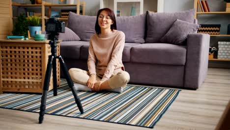 Cheerful-woman-speaking-gesturing-recording-video-at-home-for-online-blog