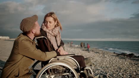 Female-wheelchair-user-and-her-boyfriend-are-chatting-and-viewing-seascape