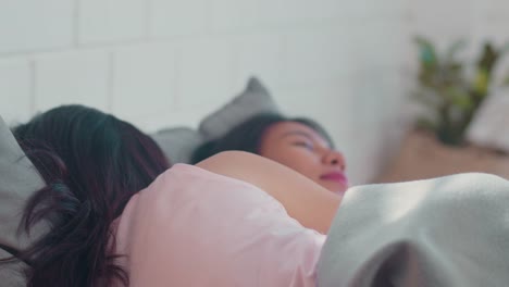 Asian-Lesbian-couple-relax-rest-together-after-wake-up-lying-on-bed-in-bedroom.